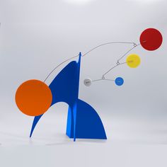 an abstract sculpture with multiple colored balls on it's back and sides, against a white background