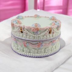 a decorated cake sitting on top of a white table next to a pink wall and window