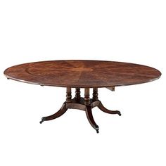 an oval dining table with four pedestals and two leaves on each end, in walnut