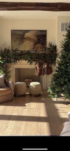 a living room filled with furniture and a fire place next to a christmas tree covered mantel