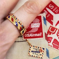 It’s always more exciting to get something in the mail. Our gold vermeil air mail ring carries on the personal tradition of sending something through the post and the signature aesthetic that comes with it. The band showcases the classic alternating red and blue dashed pattern in bold enamel with “Par Avion >> Air Mail” engraved around the top. Style it with a matching metal air mail charm or stacks of color enamel rings. Also available in a slim design. Signed Sealed Delivered, Enamel Rings, Signature Aesthetic, Color Rings, Ring Guide, Thick Ring, Going Places, Enamel Ring, Rings Set