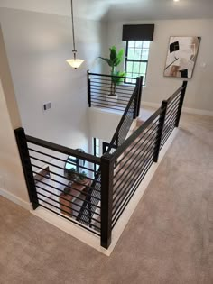 an overhead view of a living room and staircase in a house with carpeted flooring