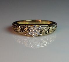 a gold and diamond ring sitting on top of a table