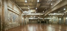 an empty room with wooden floors and chandeliers