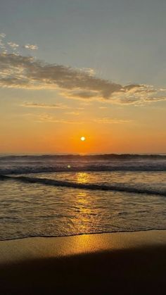 the sun is setting over the water at the beach