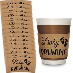 coffee cups with baby brewing labels on them and a brown paper cup next to it