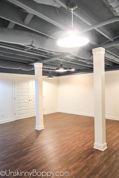 an empty room with wood floors and white columns