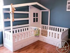 a white bunk bed with a wooden cross on the top and drawers underneath it in a blue room