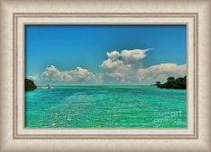 the water is very blue and green with clouds in the sky above it, as well as an island