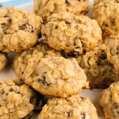 a plate full of oatmeal raisin cookies on a blue and white table cloth