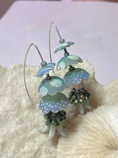 the earrings are made from glass and have flowers attached to them with pearls on them