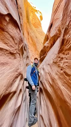 a man standing in the middle of a narrow canyon