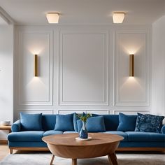 a modern living room with blue couches and white paneled wall behind the sofa