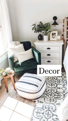 a living room with a green chair, white dresser and rug on the wooden floor