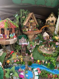 an assortment of miniature houses and trees in a display