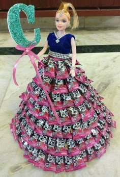 a barbie doll dressed up in a dress made out of candy bar wrappers with the number 5 on it