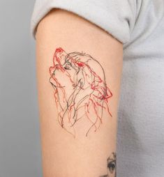 a woman's arm with a red and black ink drawing of a wolf on it