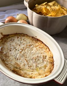 an oval casserole dish with potato chips in the bowl next to other food