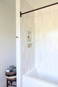 a bathroom with a tub, shelf and towel rack