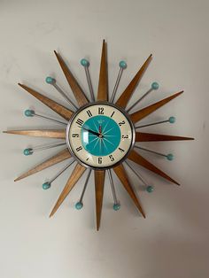 a clock that is mounted to the wall with wood and glass details on it's face