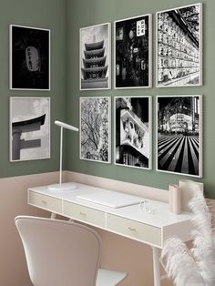 a desk with a lamp and pictures on the wall above it, along with a white chair