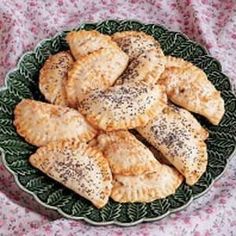 a green plate filled with pastries on top of a pink tablecloth covered table