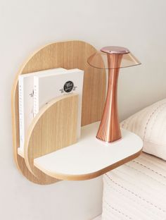 a wooden shelf with a lamp and books on it