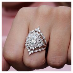 a close up of a person's hand with a diamond ring on their finger