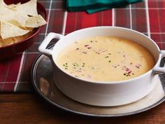 a bowl of soup with tortilla chips next to it on a tablecloth