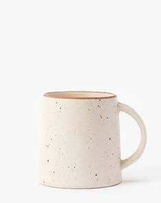 a white coffee mug with speckles on the outside and inside, sitting in front of a white background