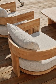 a wooden table and chair with cushions on it's back end, sitting on a deck