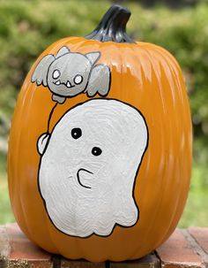 a painted pumpkin with a ghost and cat on it