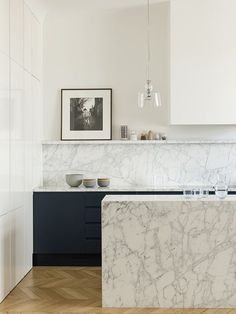 a kitchen with marble counter tops and black cabinets