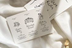 two wedding cards with handwritten names on them and a flower laying next to it