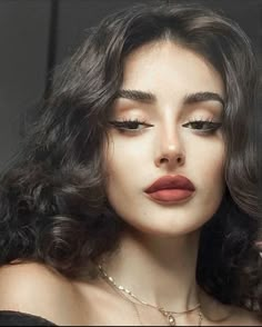 a woman with long dark hair and red lipstick