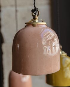 two hanging lights with one light brown and the other pink