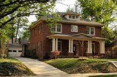 a red brick house with white trim on the front and side windows is shown in this suburban neighborhood