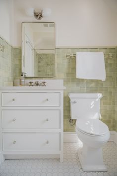 a white toilet sitting next to a bathroom sink