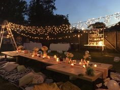 a long table with candles on it in the middle of an outdoor area at night