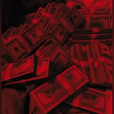 a pile of money sitting on top of a bed next to a red light in the dark