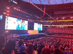 an arena full of people watching sports on large screens