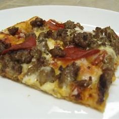 a slice of pizza on a plate with sausage and pepperoni toppings, ready to be eaten