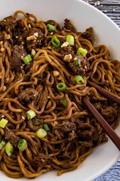 a white bowl filled with beef and noodles