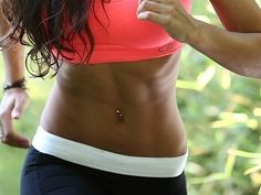 a close up of a person in a sports bra top and shorts holding a cell phone