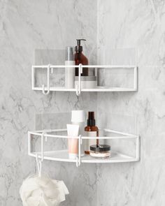 two white shelves with soap, lotion and other items on them in a bathroom