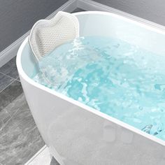 a white bath tub filled with water next to a tiled floor