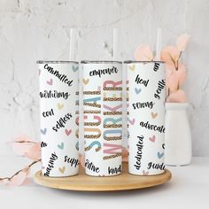 three personalized tumblers on a tray with pink flowers in the background and white wall behind them