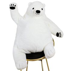 a large white teddy bear sitting on top of a chair with its arms in the air