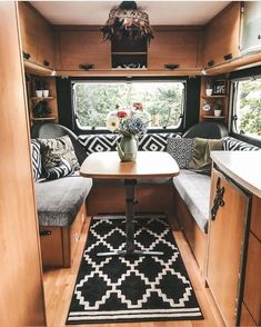 a kitchen area with a table, bench and couch in the back of an rv