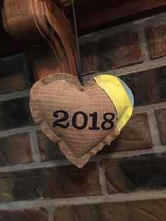 a heart hanging from the side of a brick wall